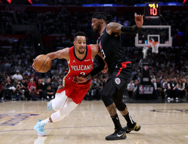 CJ McCollum #3 of the New Orleans Pelicans is fouled by Robert Covington #23 of the LA Clippers as he drives to the basket during a 105-101 Pelican win in an NBA play-in tournament game at Crypto.com Arena on April 15, 2022 in Los Angeles, California. Harry How/Getty Images/AFP NOTE TO USER: User expressly acknowledges and agrees that, by downloading and/or using this Photograph, user is consenting to the terms and conditions of the Getty Images License Agreement. Mandatory Copyright Notice: Copyright 2022 NBAE (Photo by Harry How / GETTY IMAGES NORTH AMERICA / Getty Images via AFP)
